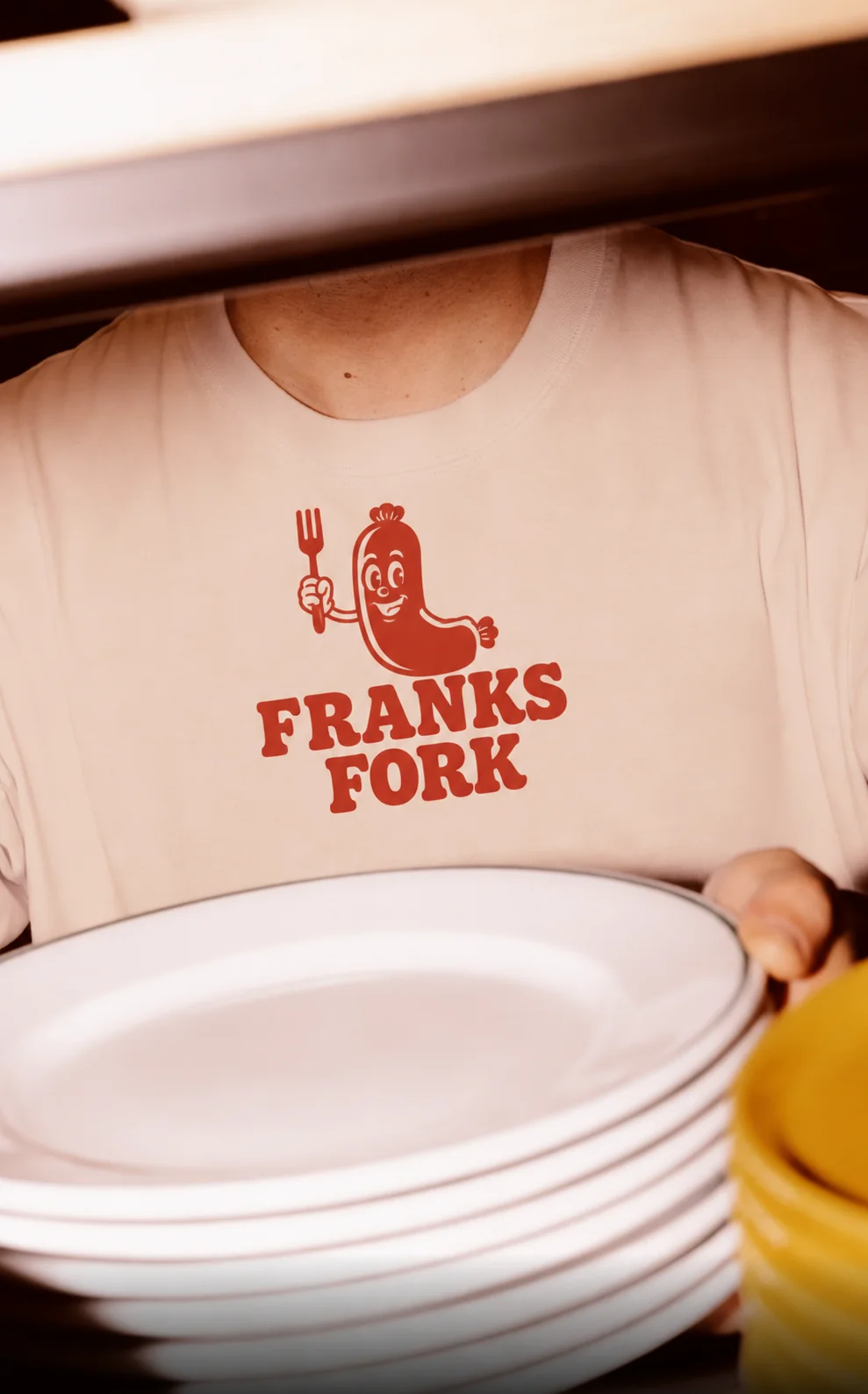 Franks Fork cream t-shirt carrying the red sausage mascot