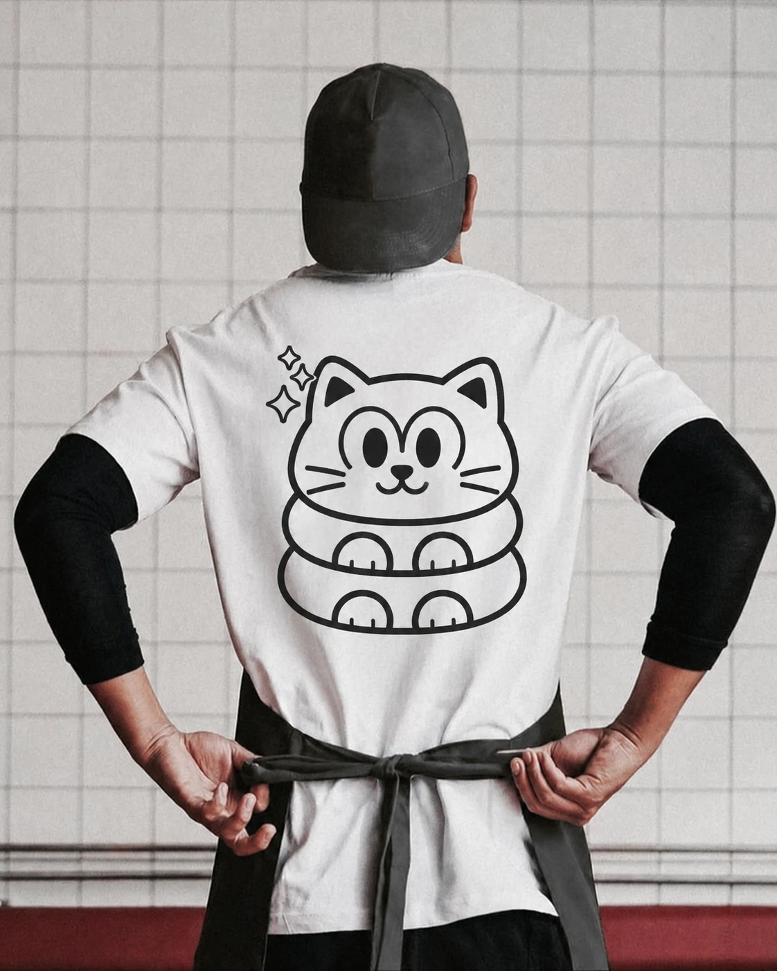 Kata Cat staff tee (back) with the cat mark, worn with cap and apron